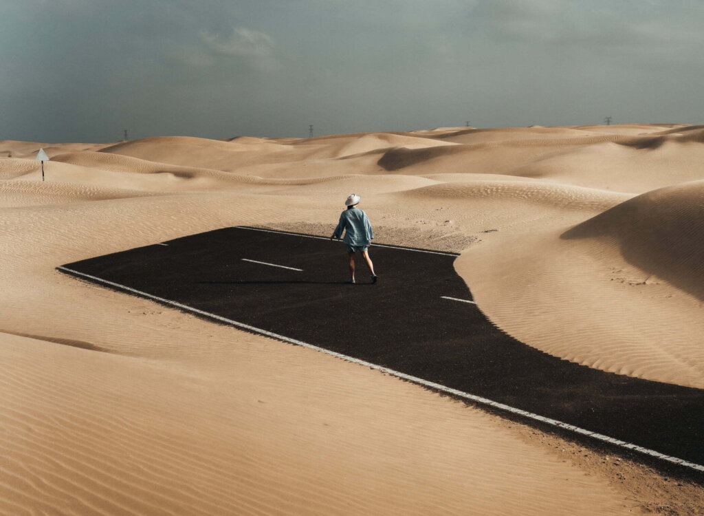 Woman Walking On Highway In Desert