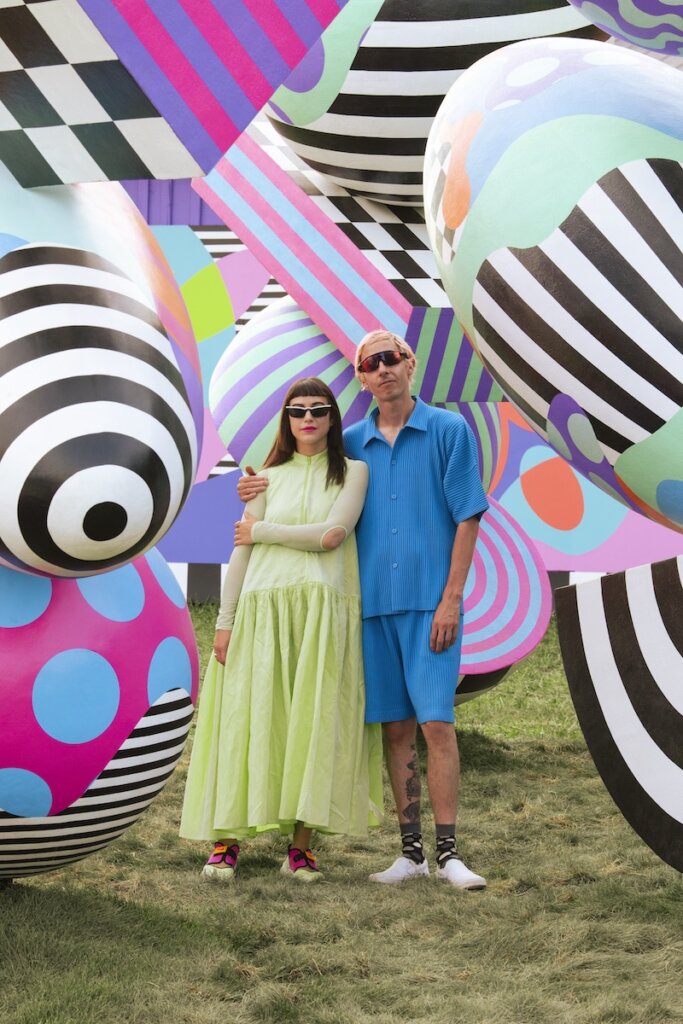 Wade and Leta posing in front of their work titled "Paint Your Own Path" for Toyota, Bonnaroo, and Saatchi & Saatchi