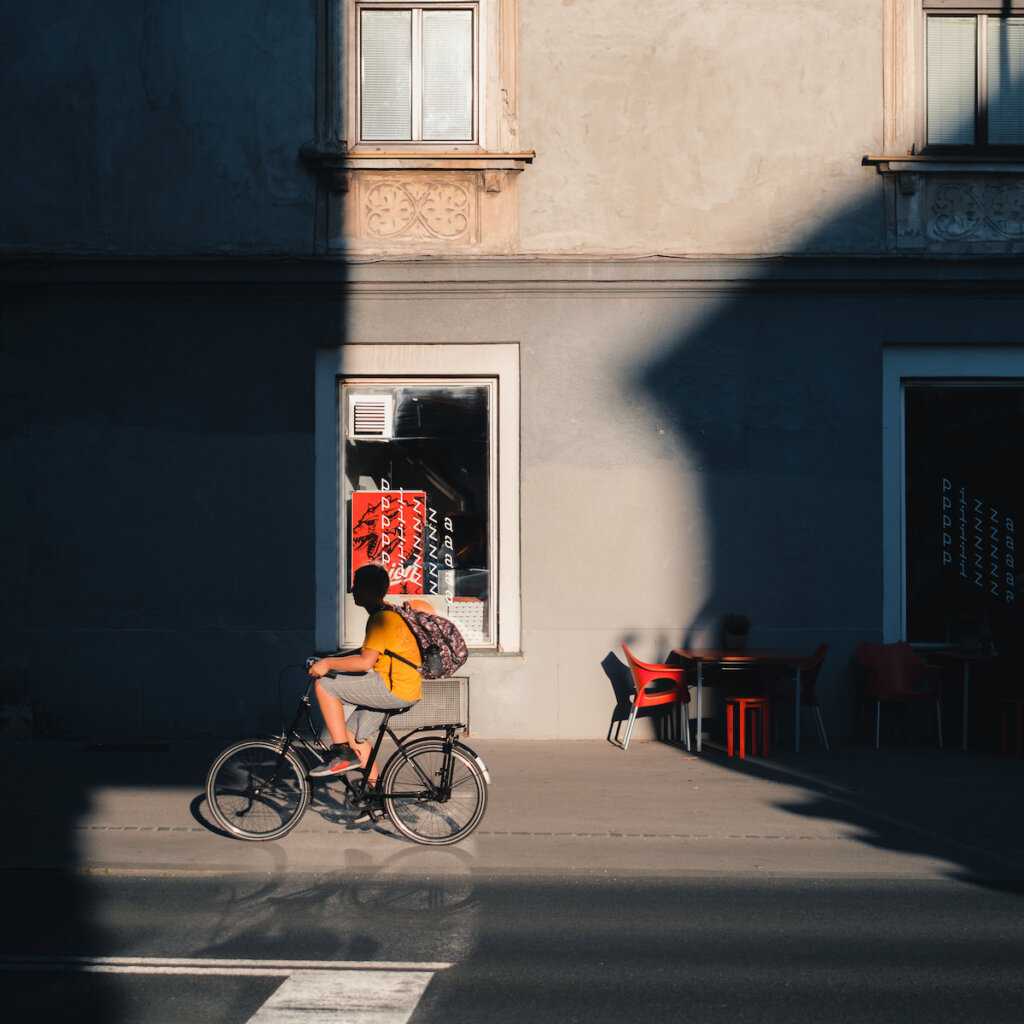 Man Riding A Bicycle By The Sidewalk In Daytime